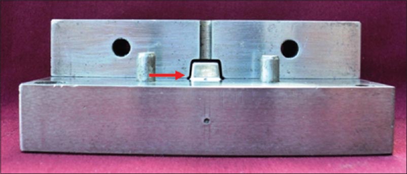 Figure 3: Machined split assembly containing master die with 0.5 mm space for wax patterns of uniform size (arrow showing the space)